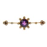 An early 20th century amethyst and split pearl bar brooch. The circular-shape amethyst, within a