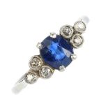 A mid 20th century platinum and 18ct gold sapphire and diamond ring. The oval-shape sapphire, to the