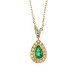 An 18ct gold emerald and diamond cluster pendant. The pear-shape emerald, within a brilliant-cut
