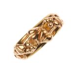 CLOGAU - a 9ct gold ring. Of bi-colour design, the openwork scrolling berry and foliate motif, to