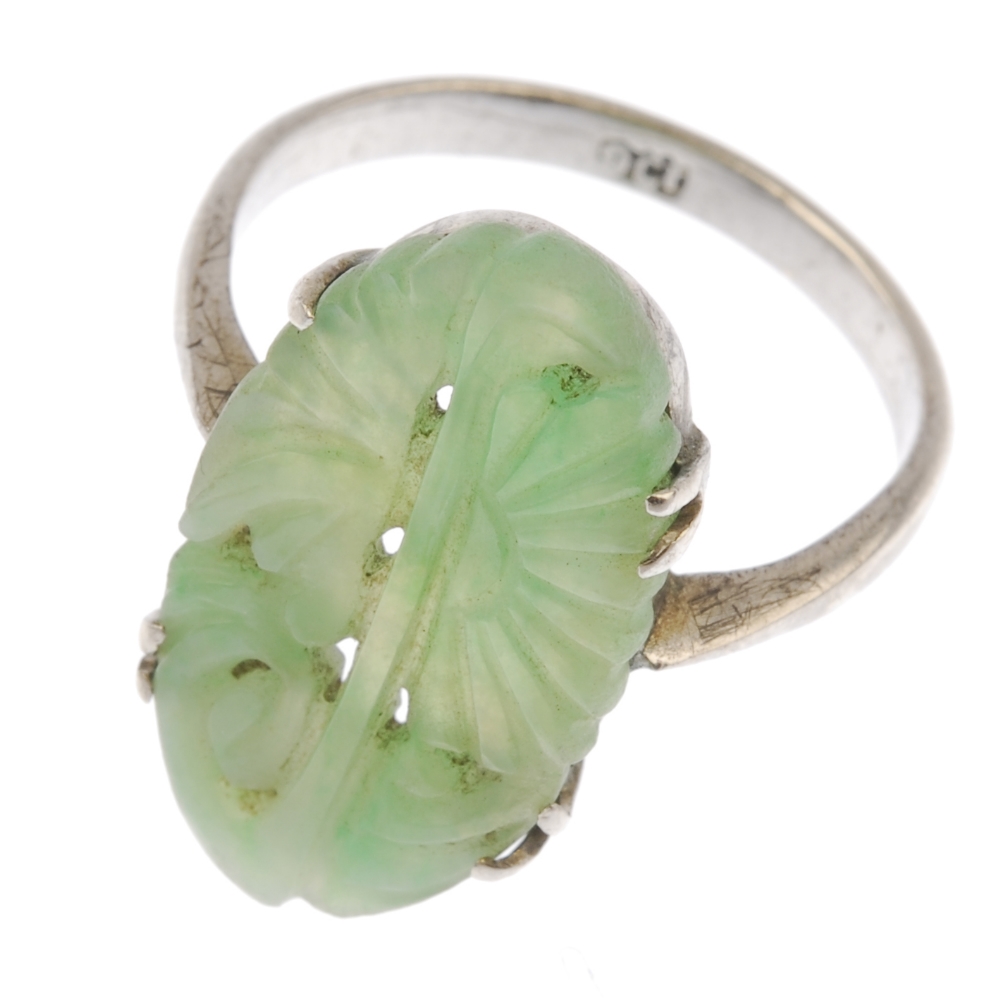 A jade ring. The carved oval jadeite panel, of foliate and openwork design, to the tapered shoulders - Image 2 of 2