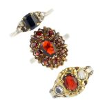 A selection of three 9ct gold gem-set dress rings. To include a garnet cluster ring, a garnet and