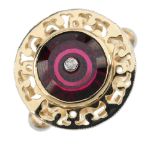 A 9ct gold garnet and diamond dress ring. The brilliant-cut diamond collet, inset to the circular-