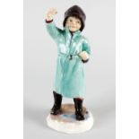 A Royal Worcester figure, 'February', modelled as a child wearing green rain mac, hat and wellies,