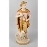 A Royal Dux figure, modelled as a shepherd carrying saddle bag and wooden staff stood beside dog, on