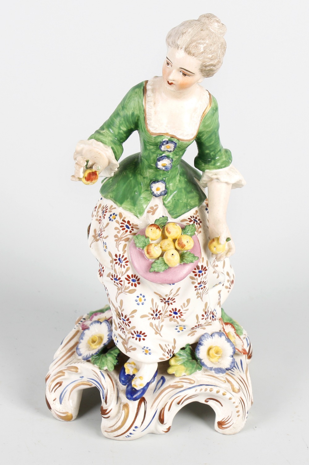 A 19th century Samson porcelain figure. Modelled as a seated fruit seller, with chignon, flower-
