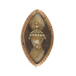 A George III gold memorial brooch. Designed as a marquise-shape decorative hair panel with mother of