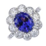 A tanzanite and diamond cluster ring. The oval-shape tanzanite, within a brilliant-cut diamond