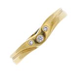 An 18ct gold diamond band ring. The brilliant-cut diamond, with similarly-cut diamond sides, to