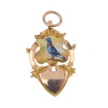 An early 20th century 9ct gold enamel pigeon medal. The shield-shape enamel panel, depicting a