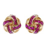 A pair of 9ct gold ruby ear clips. Each designed as a stylised knot, inset with circular-shape