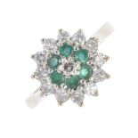 A 9ct gold emerald and diamond cluster ring. The brilliant-cut diamond, within a circular-shape