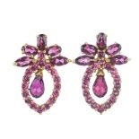 A pair of garnet earrings. Each designed as a briolette-cut purple garnet, suspended within a