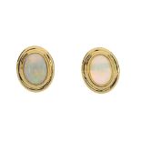 An opal pendant and pair of ear studs. The 18ct gold pendant designed as an oval opal cabochon