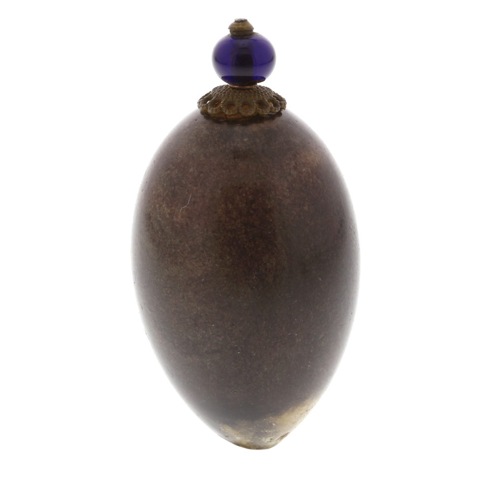 A hardstone scent bottle. The ovoid body with brown and beige hue, glowing violet under light,