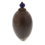 A hardstone scent bottle. The ovoid body with brown and beige hue, glowing violet under light,