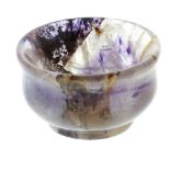 A small Blue John salt Of bulging cauldron form, with lilac and amethyst tones on a clear ground