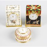 Three Halcyon Days enamel clocks. The first circular, 'The Happier the Time, The Faster it Goes',