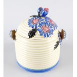 A Clarice Cliff Bizarre beehive pot, the cover decorated with blue and pink flowers upon a cream