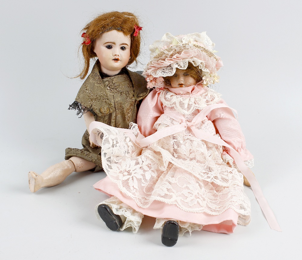 A SFBJ Bisque headed doll modelled as a young girl with opening brown glass eyes and partly open
