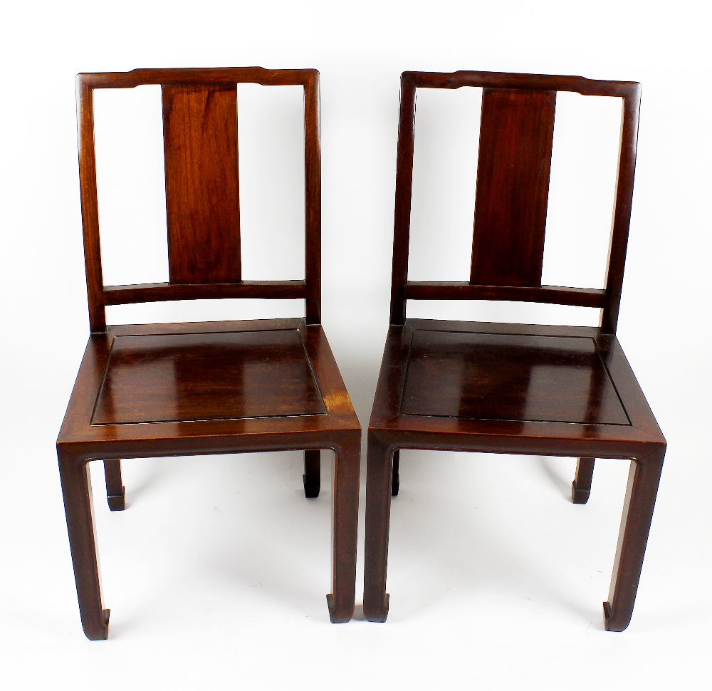 A set of four 20th century Chinese hardwood chairs, having shaped top rail and wide plain splat,