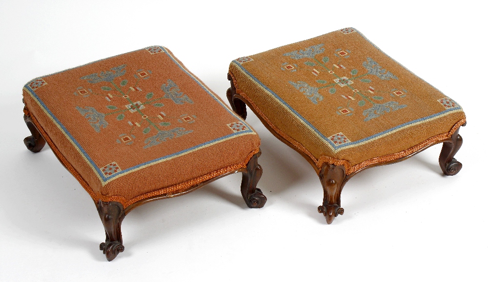 A pair of tapestry footstools. Each having foliate motif upon a pale pink ground, raised upon four