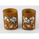A pair of Oriental carved bamboo vases, each of oval cylindrical form, the carved panel decoration
