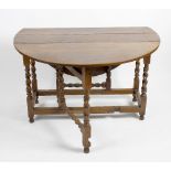 An oak drop leaf gateleg table. The oval top above single frieze drawer with false drawer verso,