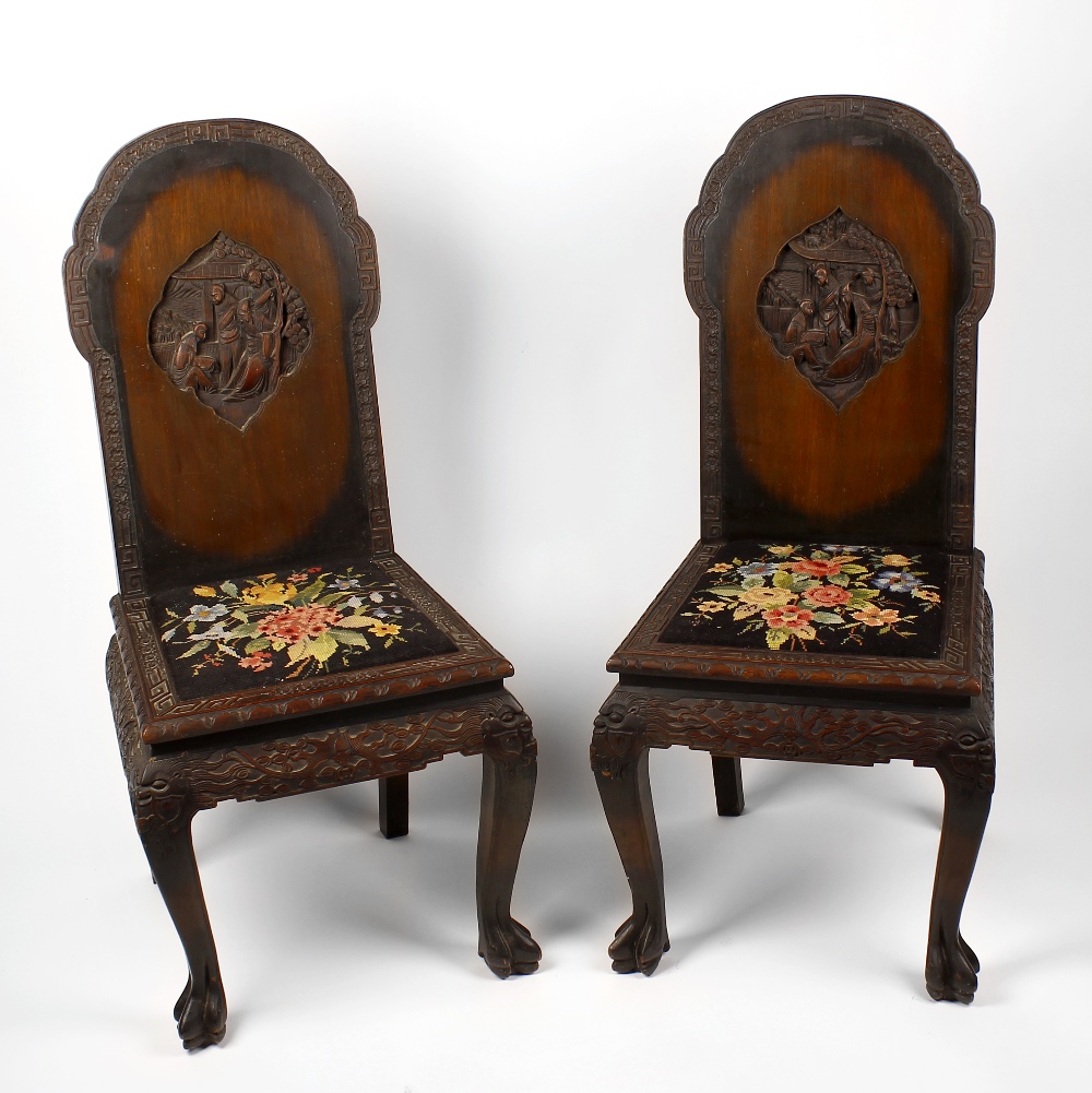 A pair of early 20th century Chinese hall chairs, each having a rounded tall back and tapestry-