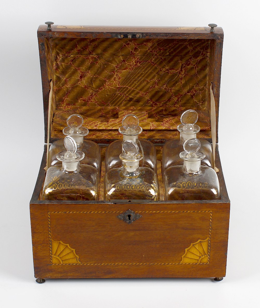 An inlaid mahogany decanter box, the hinged bow fronted cover opening to reveal a fitted interior