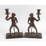 A pair of 19th century bronze candlesticks. Each modelled as an anthropomorphic monkey stood holding