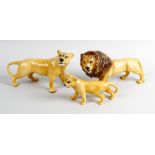 Four Beswick animals. Comprising: a family of three lions, male, female and cub, largest 8.5, (22cm)