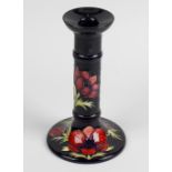 A Moorcroft 'anemone' candlestick. The knopped stem raised upon circular base, decorated with