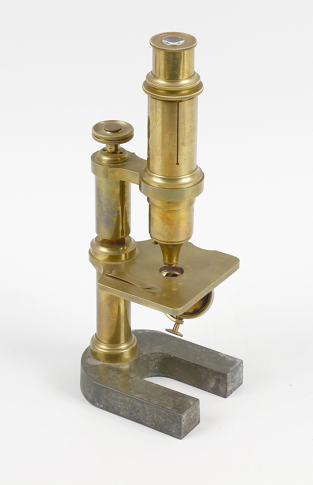 A 19th century mahogany cased brass microscope. The adjustable neck above rectangular stage and