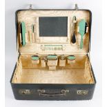 An Art Deco travelling case of small suitcase type form, the rectangular hinged cover lifting to