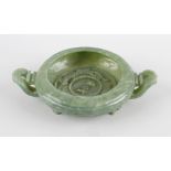 A Chinese green hard stone twin handled bowl, of circular outline, having applied ring to centre