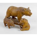 A group of three carved wooden bears. Comprising mother and two cubs, she modelled stood upon