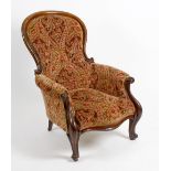 A mid 19th century mahogany-framed spoon-back easy chair. The deep-buttoned spoon back, scroll