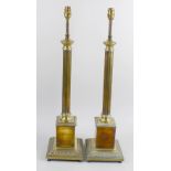 A pair of brass lamps. The square bases with moulded details supporting fluted columns terminating