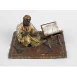 A Franz Bergmann cold painted bronze, depicting an Arab scribe, seated upon a rug, impressed marks