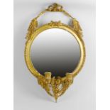 A gilt wall mirror or girandole. The circular plate within gilt frame with beaded detail, having