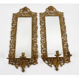 A pair of late 19th century brass wall mirrors. The bevelled rectangular silvered mirror plates