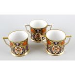 Two Hamilton Derby porcelain mugs, one with twin handles, the other single, each having Imari