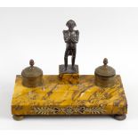 A French Empire Sienna marble inkstand, surmounted with a central bronze figure of Napoleon, flanked