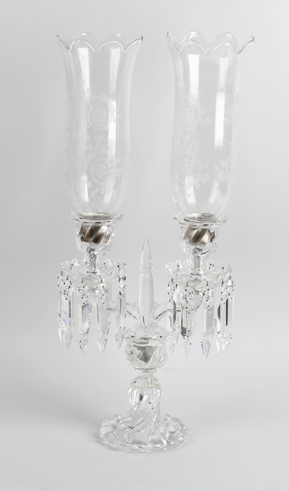 A Baccarat twin branch candelabra. The fluted socles each having pendant drops leading to the