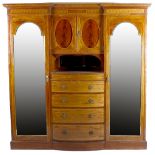 A large inlaid wardrobe. Of inverted break form form having central twin door cupboard above inset