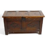 An antique oak bedding chest. Having carved frieze above a panelled front decorated with further