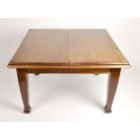 An early 20th century mahogany wind out extending dining table, of square outline with one