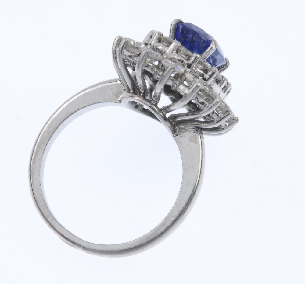 A sapphire and diamond cluster ring. The oval-shape sapphire, within a brilliant-cut diamond - Image 4 of 4