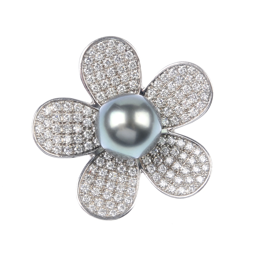 A cultured pearl and diamond flower ring. The grey cultured pearl, measuring 12.8mms, within a